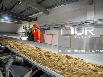 Workers carry out a routine inspection on a conveyor belt at the Ferris Chong phosphate mine in Hualuo village, Sanjia street, Zhijin County...