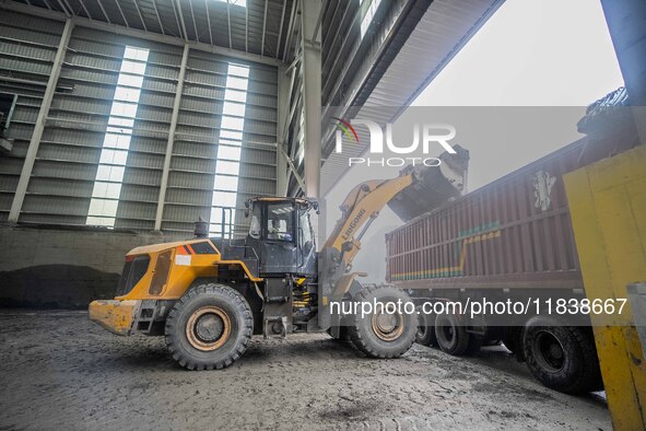 Workers load phosphate ore products at the plant of the Ferriichong phosphorus mine in Hualuo village, Sanjia street, Zhijin County, in Biji...