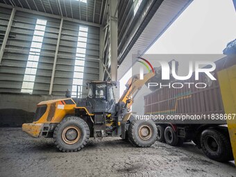 Workers load phosphate ore products at the plant of the Ferriichong phosphorus mine in Hualuo village, Sanjia street, Zhijin County, in Biji...