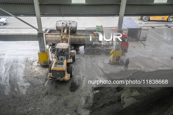 Workers load phosphate ore products at the plant of the Ferriichong phosphorus mine in Hualuo village, Sanjia street, Zhijin County, in Biji...