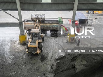 Workers load phosphate ore products at the plant of the Ferriichong phosphorus mine in Hualuo village, Sanjia street, Zhijin County, in Biji...