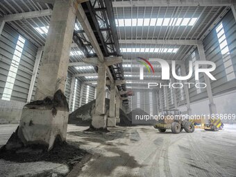 Workers load phosphate ore products at the plant of the Ferriichong phosphorus mine in Hualuo village, Sanjia street, Zhijin County, in Biji...