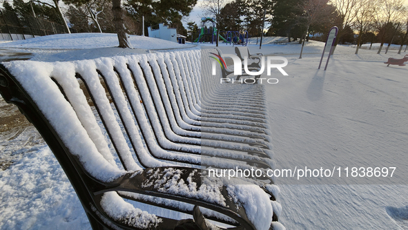 Snow covers a park bench following the first snowfall of the season in Toronto, Ontario, Canada, on December 5, 2024. 