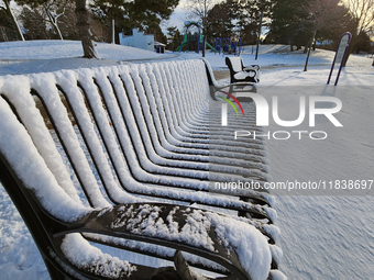 Snow covers a park bench following the first snowfall of the season in Toronto, Ontario, Canada, on December 5, 2024. (