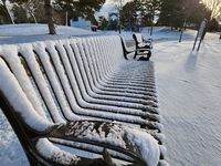 Snow covers a park bench following the first snowfall of the season in Toronto, Ontario, Canada, on December 5, 2024. (