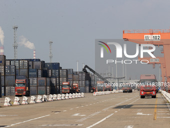 Freight cars transport containers in preparation for a rail-sea intermodal train in Qinzhou City, South China, on December 5, 2024. (