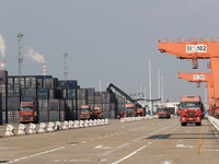 Freight cars transport containers in preparation for a rail-sea intermodal train in Qinzhou City, South China, on December 5, 2024. (