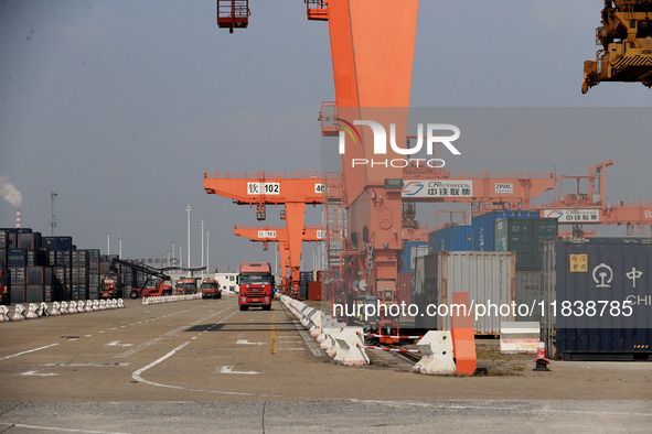 Freight cars transport containers in preparation for a rail-sea intermodal train in Qinzhou City, South China, on December 5, 2024. 