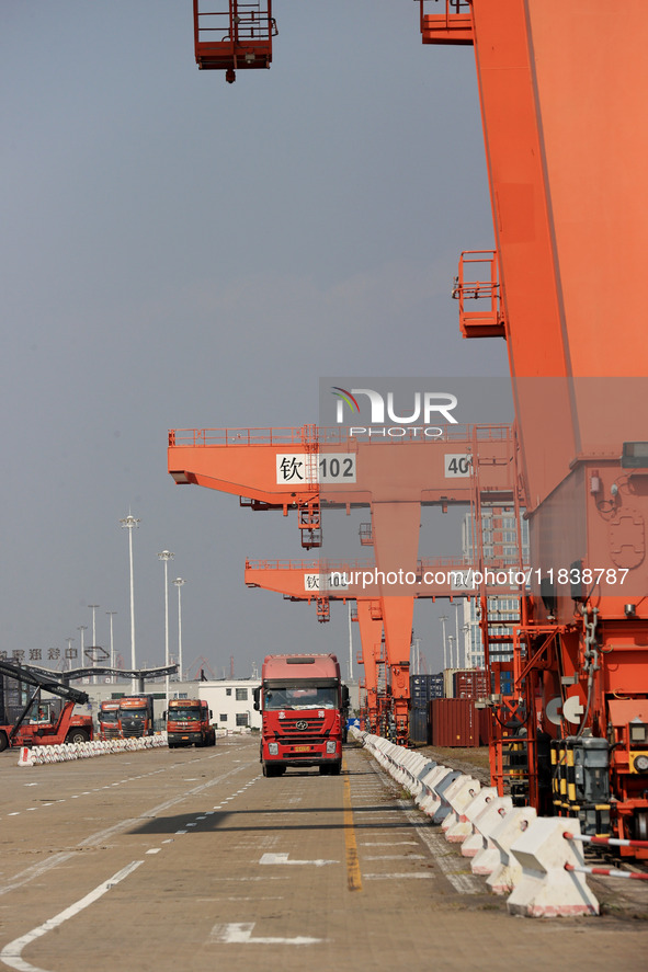 Freight cars transport containers in preparation for a rail-sea intermodal train in Qinzhou City, South China, on December 5, 2024. 