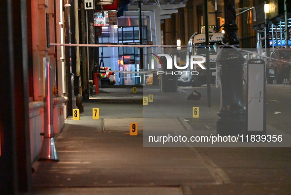 NYPD Crime Scene Unit investigators mark the crime scene where a 17-year-old boy is killed and an 18-year-old man is injured after they are...