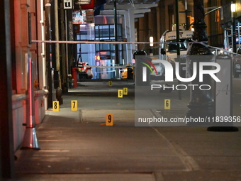 NYPD Crime Scene Unit investigators mark the crime scene where a 17-year-old boy is killed and an 18-year-old man is injured after they are...