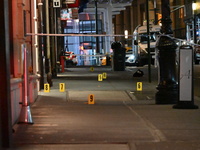 NYPD Crime Scene Unit investigators mark the crime scene where a 17-year-old boy is killed and an 18-year-old man is injured after they are...