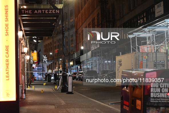 NYPD Crime Scene Unit investigators mark the crime scene where a 17-year-old boy is killed and an 18-year-old man is injured after they are...