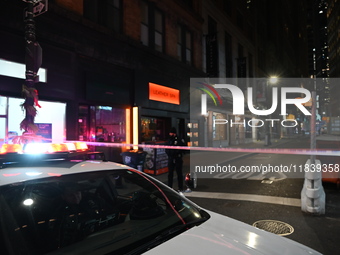 NYPD Crime Scene Unit investigators mark the crime scene where a 17-year-old boy is killed and an 18-year-old man is injured after they are...