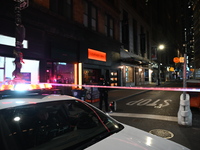 NYPD Crime Scene Unit investigators mark the crime scene where a 17-year-old boy is killed and an 18-year-old man is injured after they are...