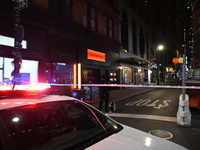 NYPD Crime Scene Unit investigators mark the crime scene where a 17-year-old boy is killed and an 18-year-old man is injured after they are...