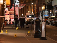 NYPD Crime Scene Unit investigators mark the crime scene where a 17-year-old boy is killed and an 18-year-old man is injured after they are...