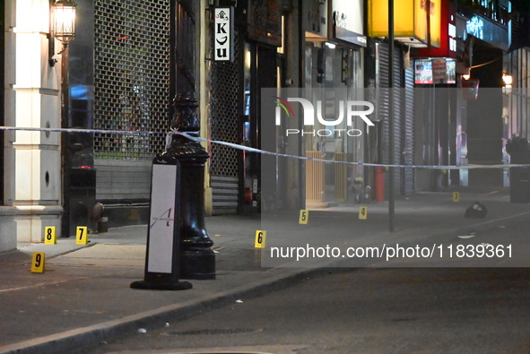 NYPD Crime Scene Unit investigators mark the crime scene where a 17-year-old boy is killed and an 18-year-old man is injured after they are...