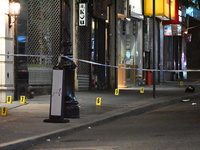 NYPD Crime Scene Unit investigators mark the crime scene where a 17-year-old boy is killed and an 18-year-old man is injured after they are...