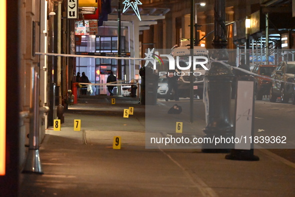 NYPD Crime Scene Unit investigators mark the crime scene where a 17-year-old boy is killed and an 18-year-old man is injured after they are...