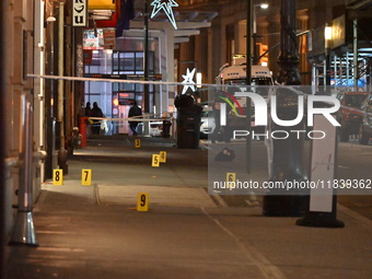 NYPD Crime Scene Unit investigators mark the crime scene where a 17-year-old boy is killed and an 18-year-old man is injured after they are...