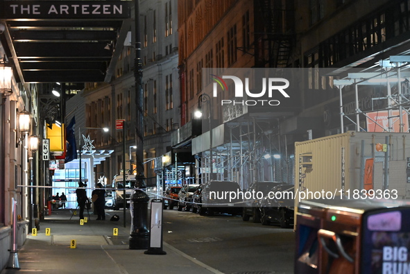 NYPD Crime Scene Unit investigators mark the crime scene where a 17-year-old boy is killed and an 18-year-old man is injured after they are...