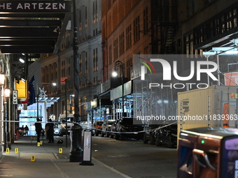 NYPD Crime Scene Unit investigators mark the crime scene where a 17-year-old boy is killed and an 18-year-old man is injured after they are...