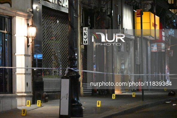 NYPD Crime Scene Unit investigators mark the crime scene where a 17-year-old boy is killed and an 18-year-old man is injured after they are...