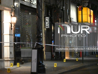 NYPD Crime Scene Unit investigators mark the crime scene where a 17-year-old boy is killed and an 18-year-old man is injured after they are...