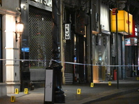 NYPD Crime Scene Unit investigators mark the crime scene where a 17-year-old boy is killed and an 18-year-old man is injured after they are...