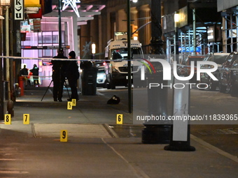 NYPD Crime Scene Unit investigators mark the crime scene where a 17-year-old boy is killed and an 18-year-old man is injured after they are...