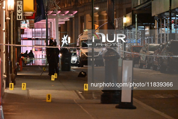 NYPD Crime Scene Unit investigators mark the crime scene where a 17-year-old boy is killed and an 18-year-old man is injured after they are...