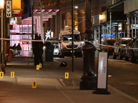 NYPD Crime Scene Unit investigators mark the crime scene where a 17-year-old boy is killed and an 18-year-old man is injured after they are...