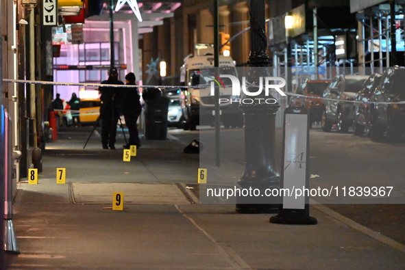 NYPD Crime Scene Unit investigators mark the crime scene where a 17-year-old boy is killed and an 18-year-old man is injured after they are...