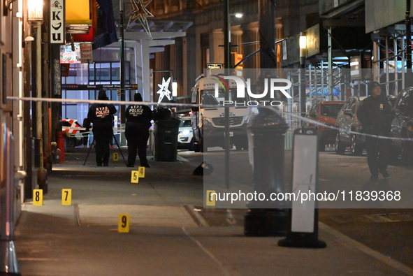 NYPD Crime Scene Unit investigators mark the crime scene where a 17-year-old boy is killed and an 18-year-old man is injured after they are...