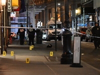 NYPD Crime Scene Unit investigators mark the crime scene where a 17-year-old boy is killed and an 18-year-old man is injured after they are...