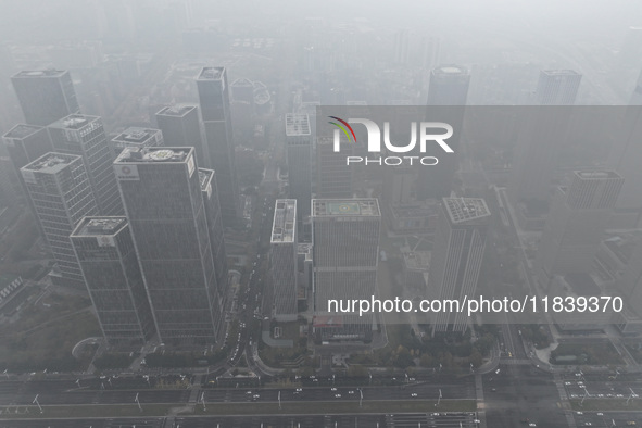 High-rise buildings loom amid heavy fog in Nanjing, Jiangsu province, China, on December 6, 2024. 