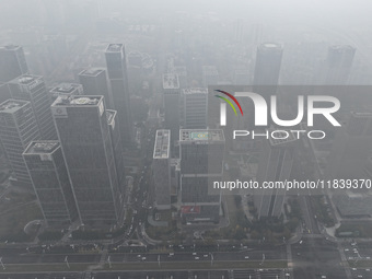 High-rise buildings loom amid heavy fog in Nanjing, Jiangsu province, China, on December 6, 2024. (