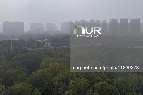 High-rise buildings loom amid heavy fog in Nanjing, Jiangsu province, China, on December 6, 2024. 