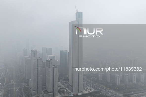 High-rise buildings loom amid heavy fog in Nanjing, Jiangsu province, China, on December 6, 2024. 