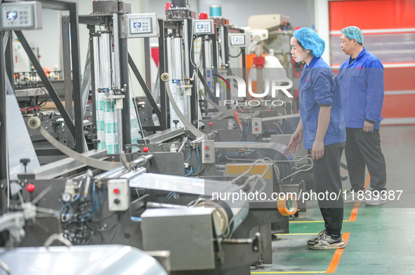 A worker produces environmentally friendly plastic bags at a workshop in Huzhou, China, on December 6, 2024. 