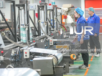 A worker produces environmentally friendly plastic bags at a workshop in Huzhou, China, on December 6, 2024. (