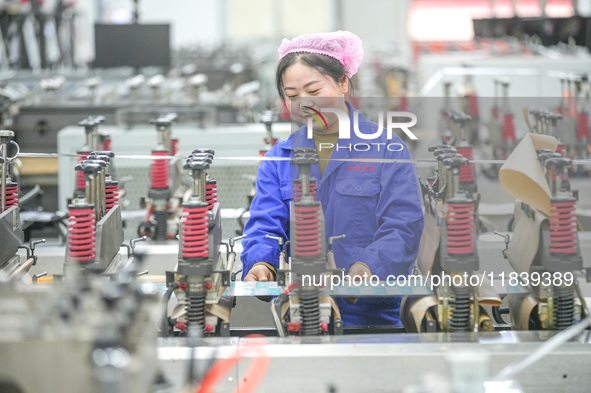 A worker produces environmentally friendly plastic bags at a workshop in Huzhou, China, on December 6, 2024. 