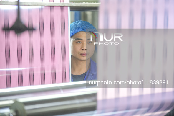 A worker produces environmentally friendly plastic bags at a workshop in Huzhou, China, on December 6, 2024. 