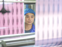 A worker produces environmentally friendly plastic bags at a workshop in Huzhou, China, on December 6, 2024. (