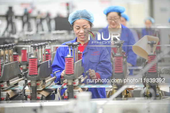 A worker produces environmentally friendly plastic bags at a workshop in Huzhou, China, on December 6, 2024. 