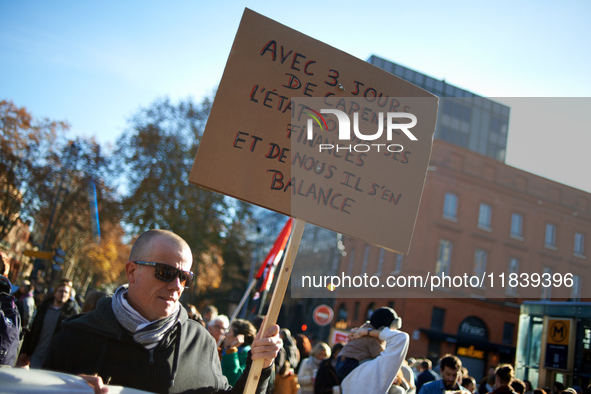 A man holds a cardboard sign that reads, 'With 3 days of waiting period, the State takes care of its money but doesn't care about us.' Betwe...