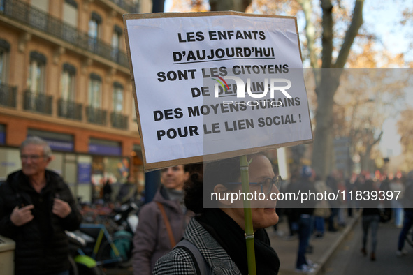 A woman holds a placard reading 'Today's children are tomorrow's citizens'. Between 8,000 and 10,000 protesters march in Toulouse, France, o...