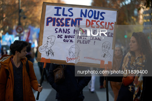 Two protesters hold a cardboard sign reading, 'They piss on us and they don't even try to persuade us it's raining.' Between 8,000 and 10,00...