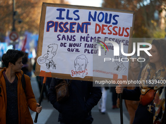 Two protesters hold a cardboard sign reading, 'They piss on us and they don't even try to persuade us it's raining.' Between 8,000 and 10,00...